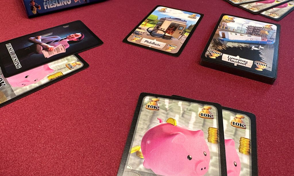 Spielkarten des Spiels Fieser Fiesling liegen auf rotem Untergrund