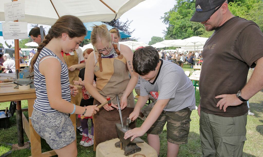 Flachsmarkt Krefeld: Kinder hämmern auf Metall in einem Amboss