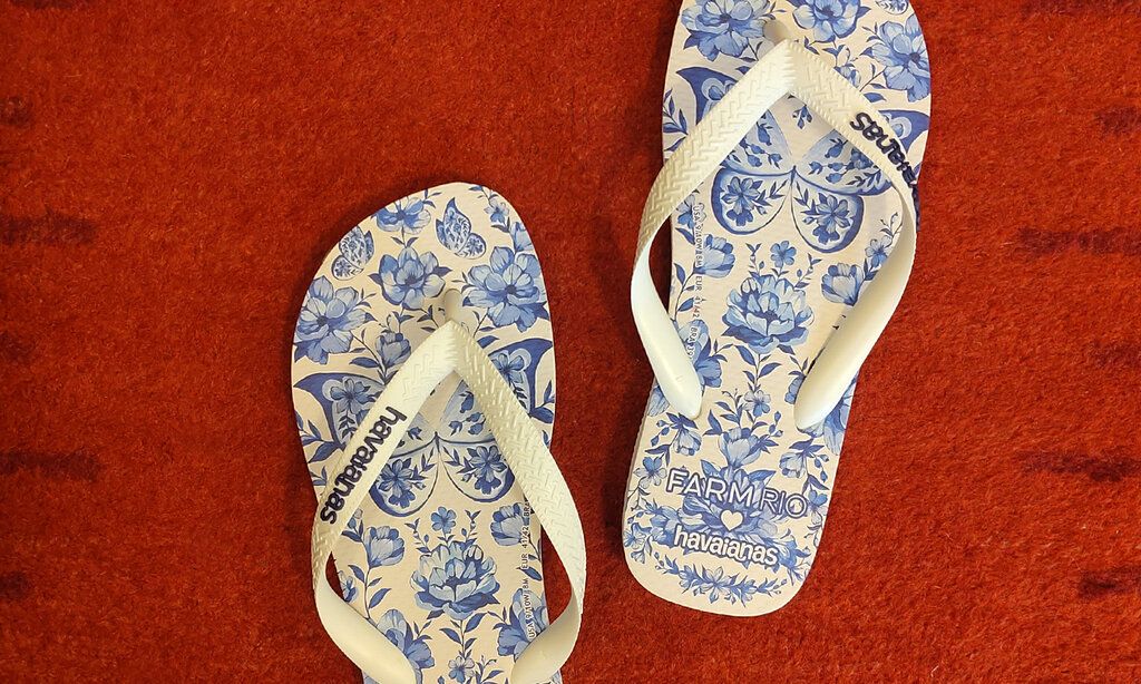 Flip-Flops mit blauem Blumenmuster auf rotem Teppich