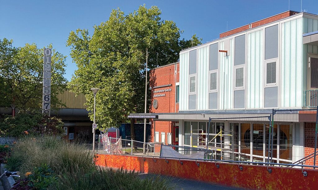 Außenansicht der Freizeitstätte Garath, Bauzaun davor, sommerlich