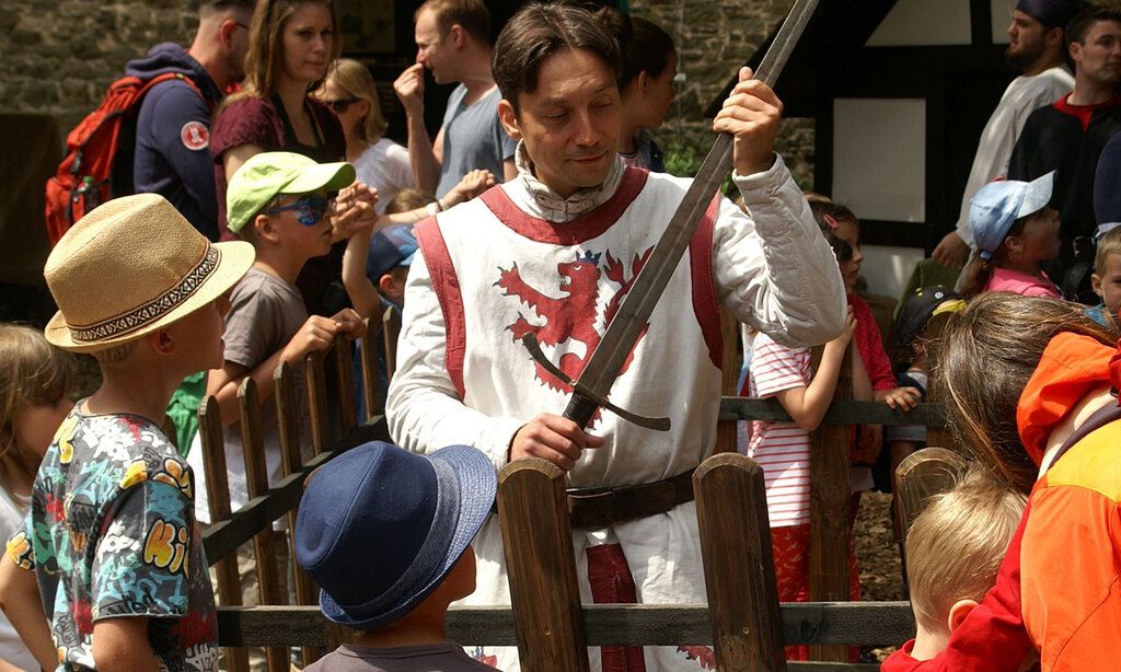 Georgs Ritter zeigt auf Schloss Burg Kindern sein Schwert