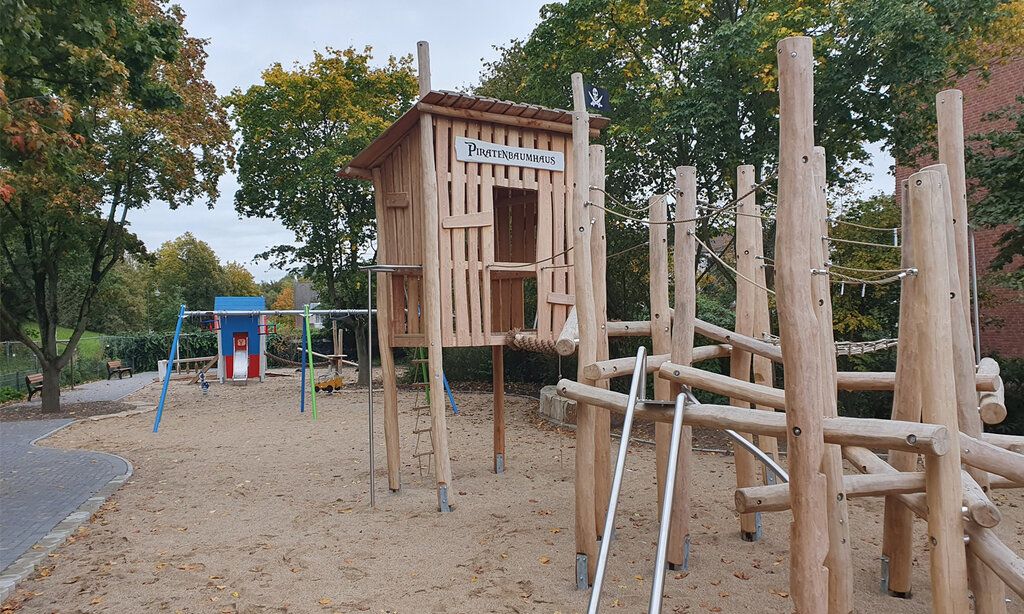 Spielplatz mit Holzhaus und Klettergerät
