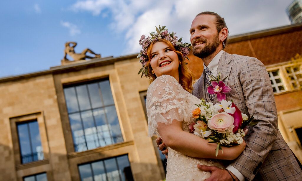 Hochzeitspaar häöt sich in den Armen, im Hintergrund  Kunstpalast Ehrenhof