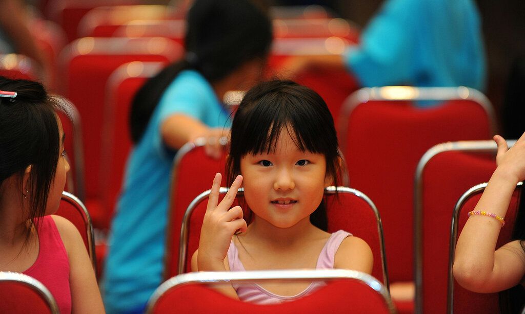 Mädchen sitzt in einer Stuhlreihe