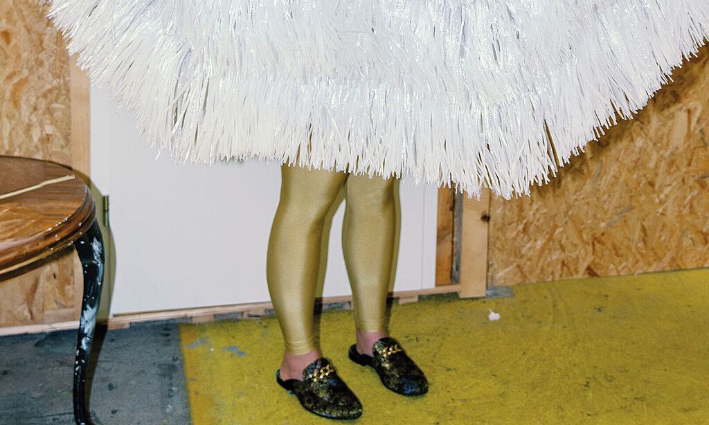 Szenenfoto zu Irgendwo ist immer Süden im Rheinischen Landestheater Neuss, man sieht Beineund eine Art Fransenrock oder Fransensonnenschirm