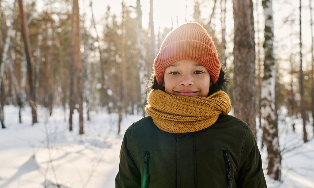 Junge im verschneiten Wald