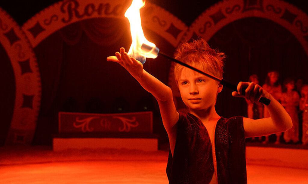 Junge mit Feuerstab im Winterzirkus