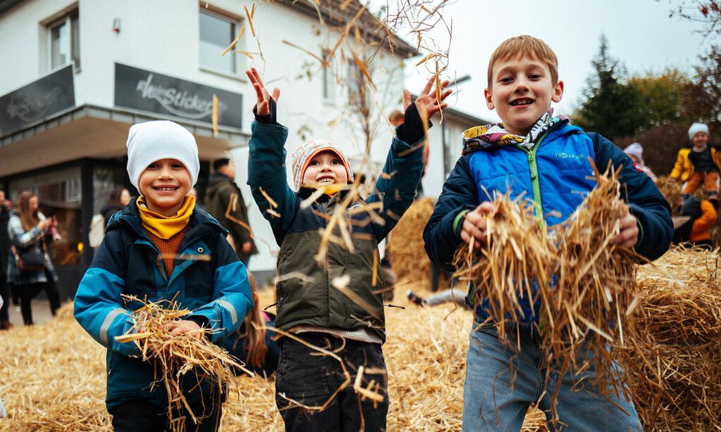 Jungs spielen mit Heu auf dem Martinsmarkt in Monheim