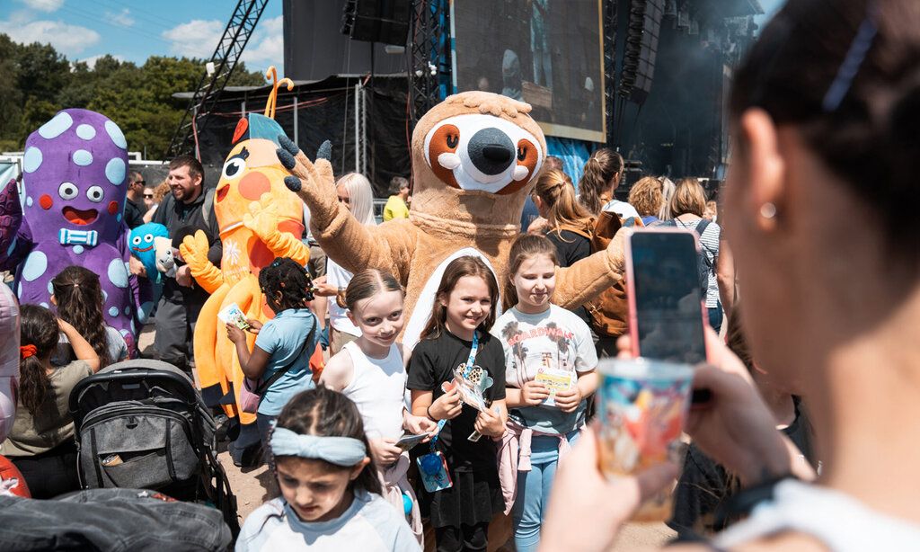 Katta-Figuren posieren mit Zuschauerinnen fürs Foto beim Katta Festival