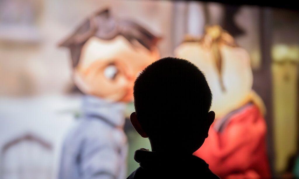 Kikife Silhouette eines Kinderkopfes vor Kino-Leinwand