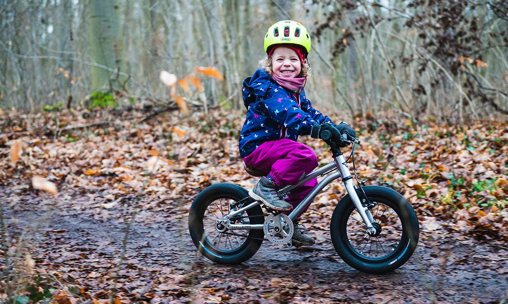 kind mit kinderfahrrad im wald