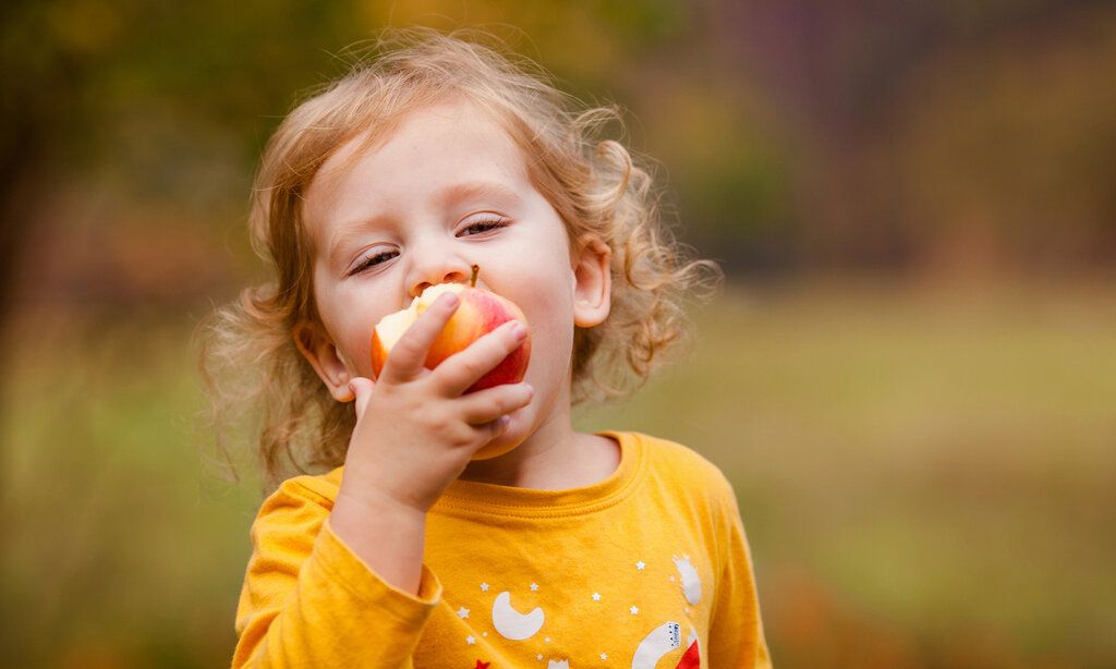 Ein Mädchen beisst in einen Apfel