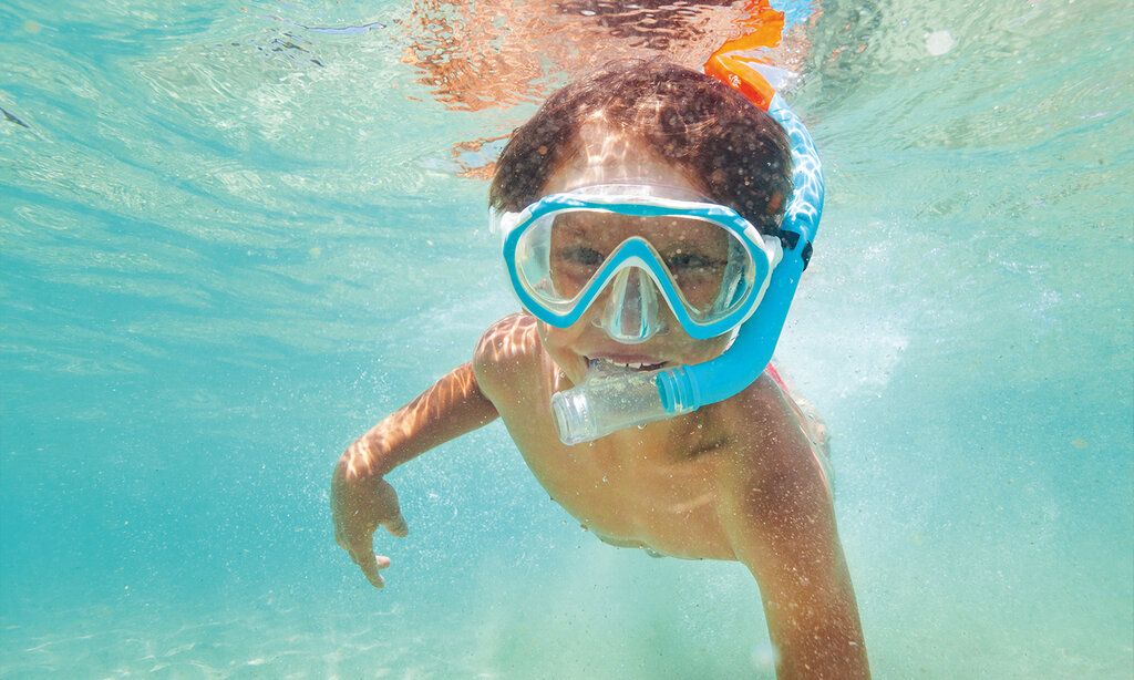 Unterwasseraufnahme von einem Kind mit Taucherbrille