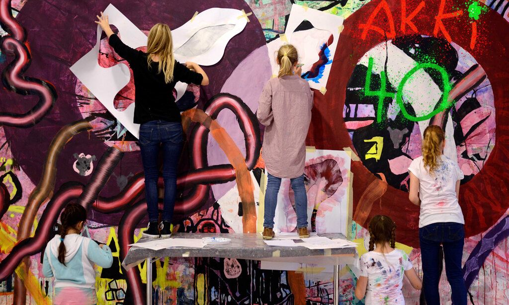 Kinder bemalen eine Wand im Akki