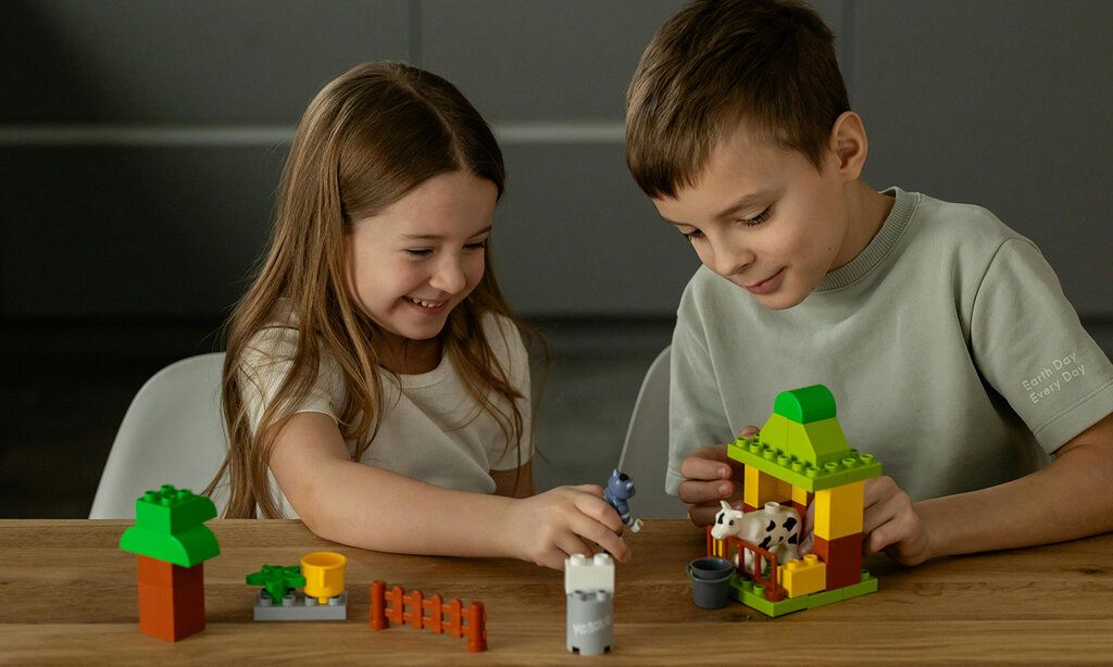 Mädchen und Junge spielen mit legoartigen Bauklötzen