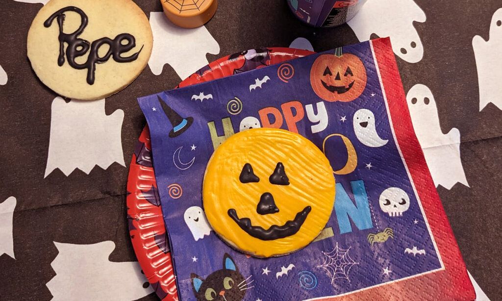 Halloweenartig gedeckter Tisch von oben mit zwei Halloweenplätzchen