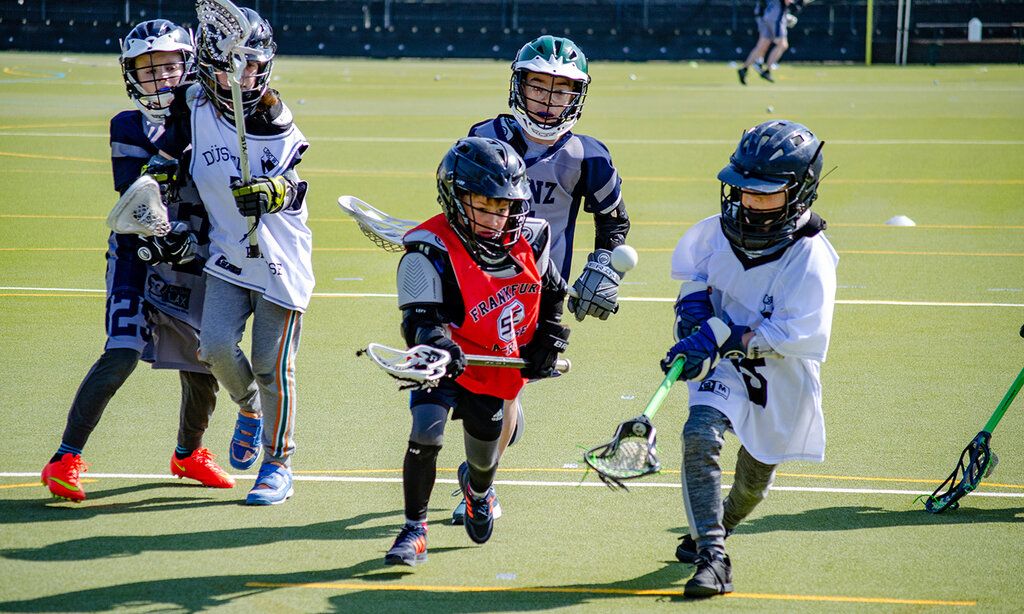Fünf Kinder spielen Lacrosse