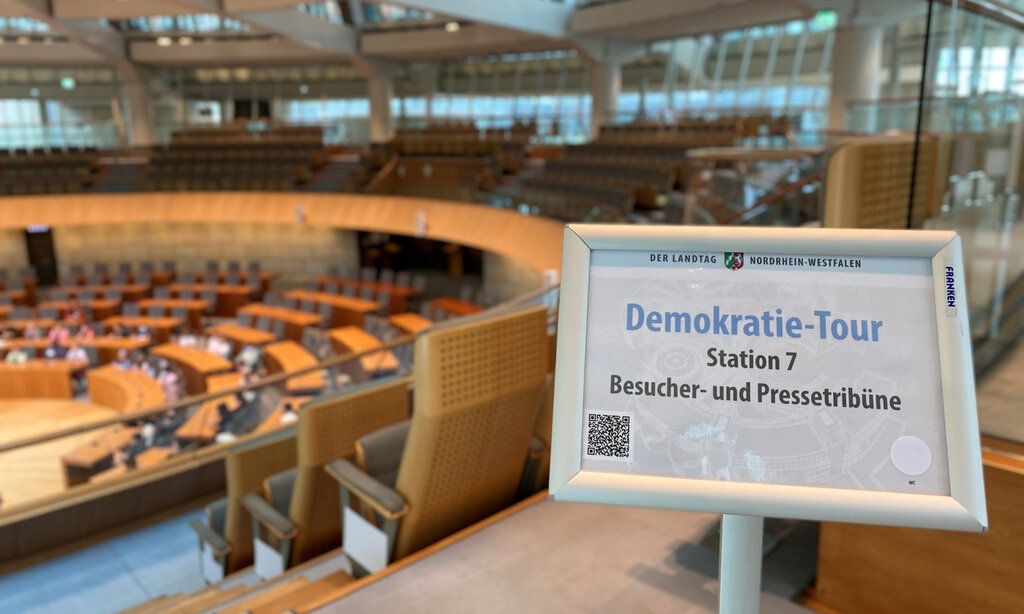 Plenarsaal des Landtags NRW mit Schild bei der Besucherführung