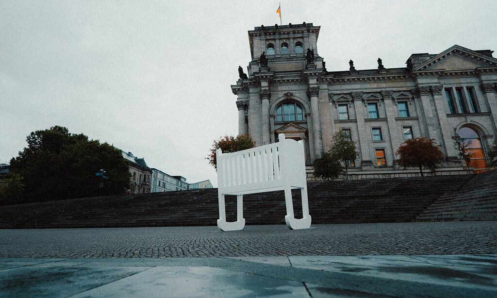überdimensionale leere Wiege steht vor dem Berliner Reichstagsgebäude