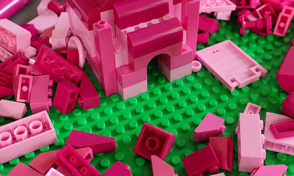 Pinke Legosteine auf grüner Bauplatte