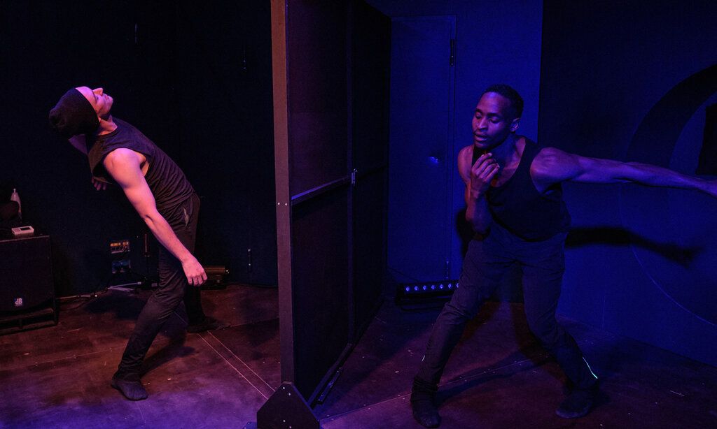 Zwei Männer tanzen in einem dunklen Raum