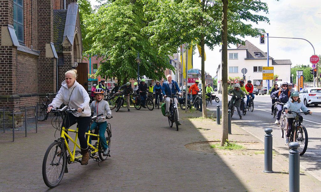 Leute fahren mit Fahrrädern durch Büderich