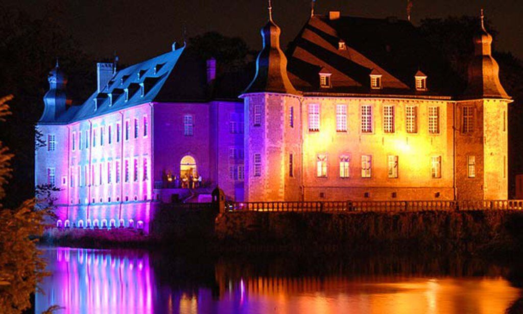 Das bunt beleuchtete Schloss Dyck bei Nacht während des Lichtfestivals.