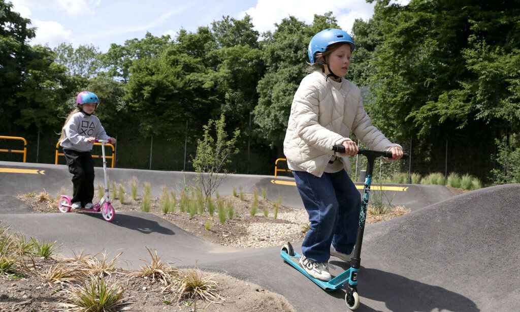 Zwei Mädchen fahren mit Scootern auf der Pumptrack-Anlage in Heerdt