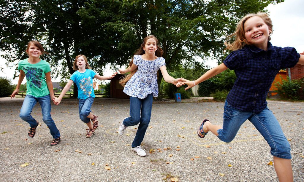 Mädchen rennen lachend über den Schulhof