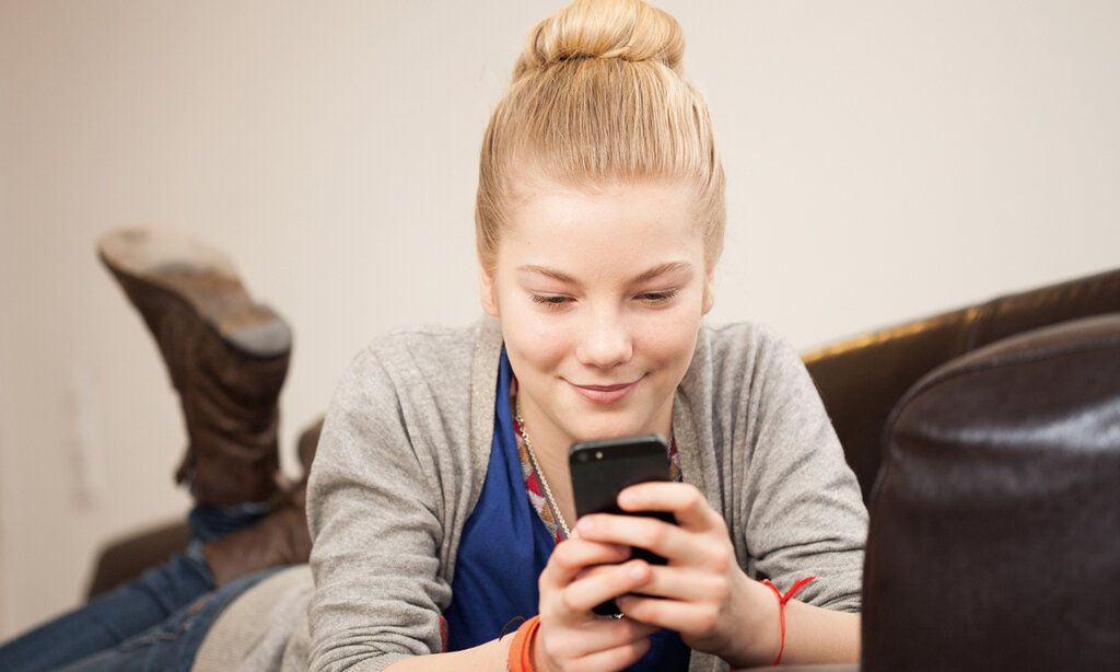 Mädchen daddelt am Smartphone