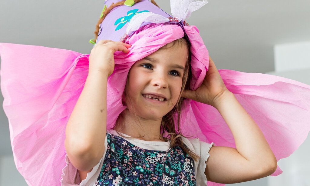 Mädchen mit rosa Schultüte auf dem Kopf