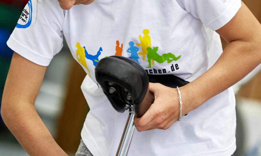 Person im Anschnitt, Einradsattel in der Hand