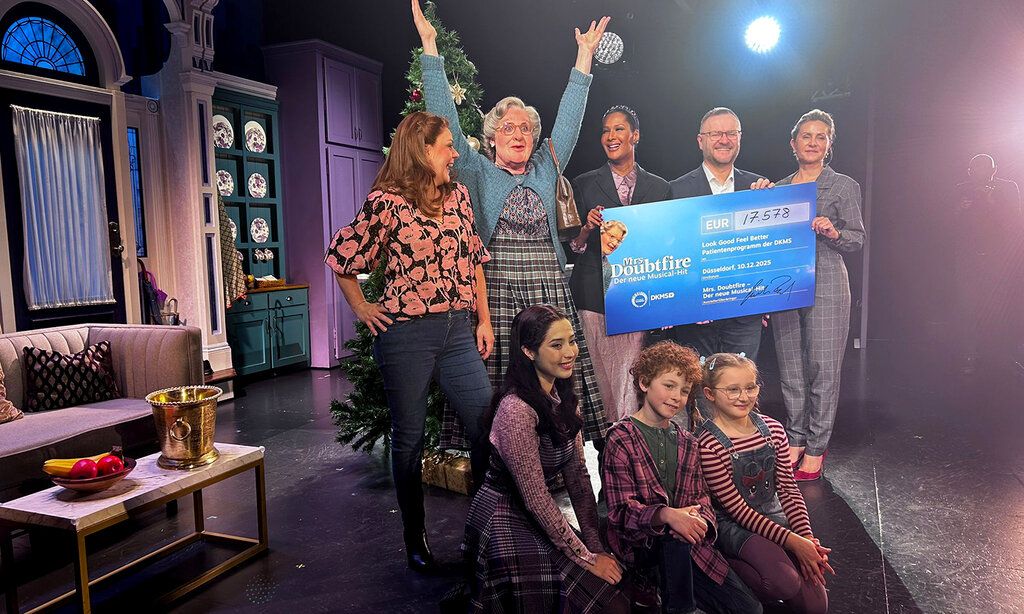 Gruppenbild, Darsteller:innen und Spender:innen bei der Mrs Doubtfire Spendenaktion auf der Bühne
