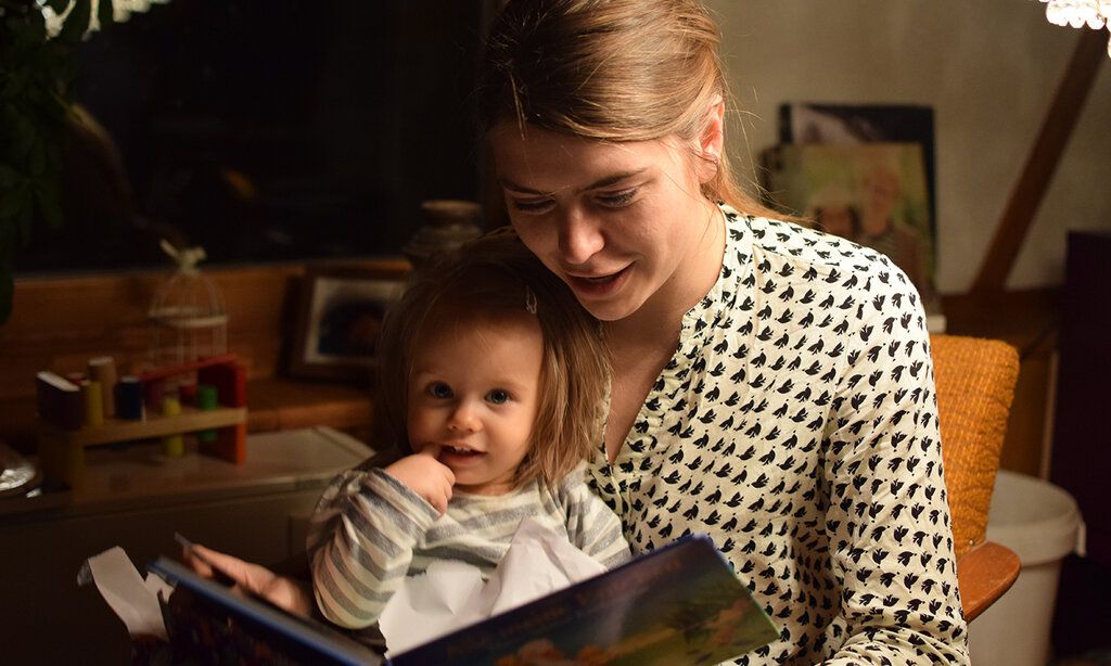 Mutter liest ihrer Tochter abends aus einem Buch vor