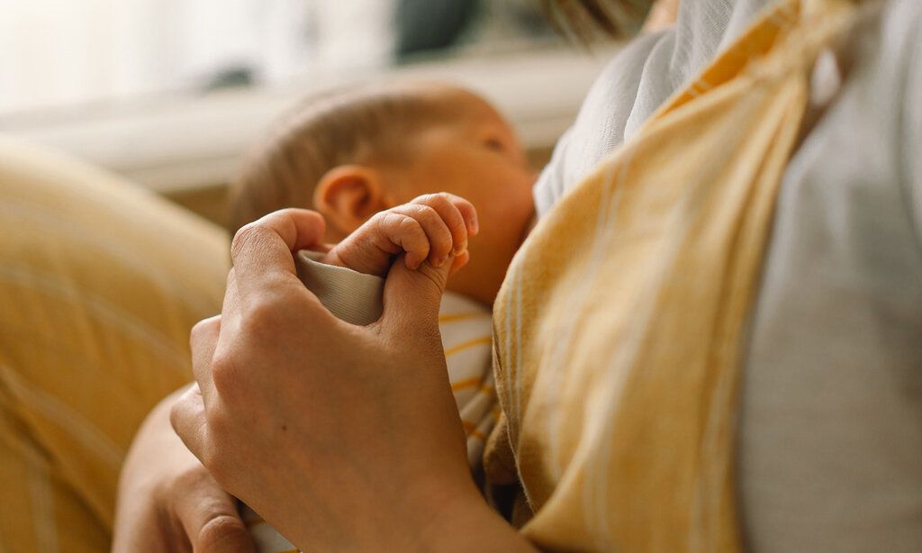 Neugeborenes trinkt an der Brust der Mutter