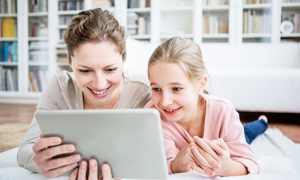 Mutter und Tochter nutzen Tablet zu Hause