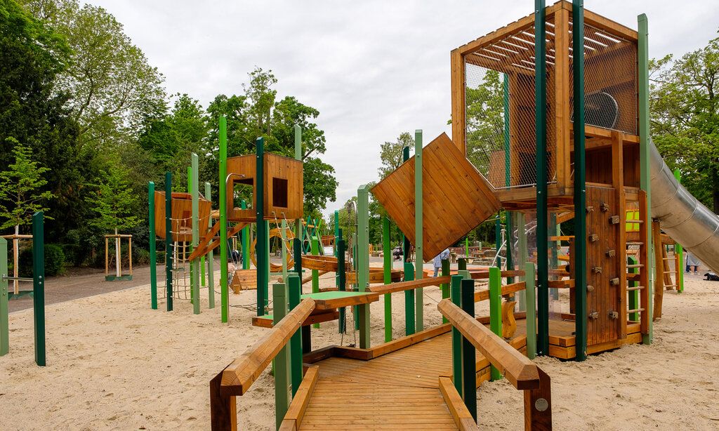 Der große Kinderspielplatz im Düsseldorfer Hofgarten ist wiedereröffnet. Der in Grüntönen gestaltete Spielplatz bietet zahlreiche Spiel-Stationen für jüngere als auch ältere Kinder. Das prägende Hauptspielgerät ist als großer Parcours gestaltet