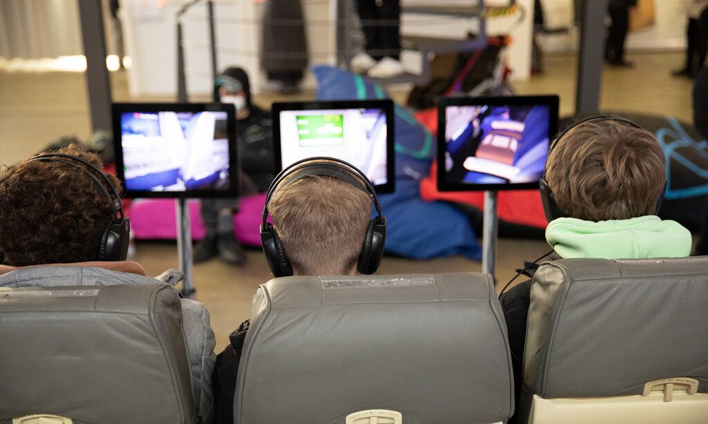 Drei Kinder von hinten, die Computerspiele spielen