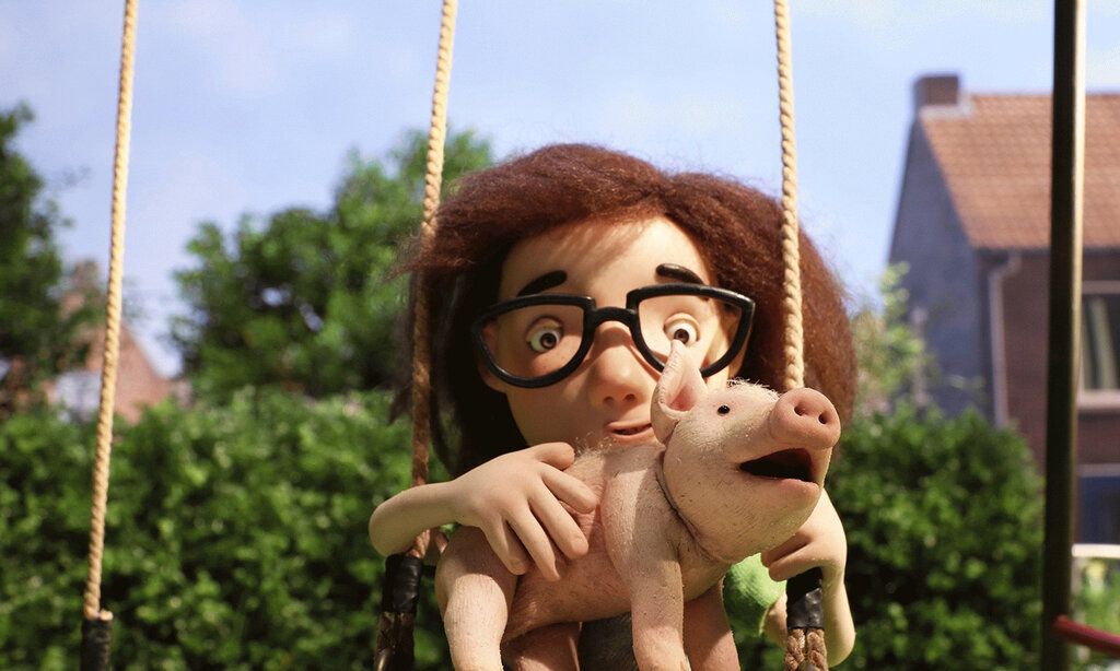 Stopp-Motion-Figur sitze mit einem Schweinchen auf einer Schaukel im Garten