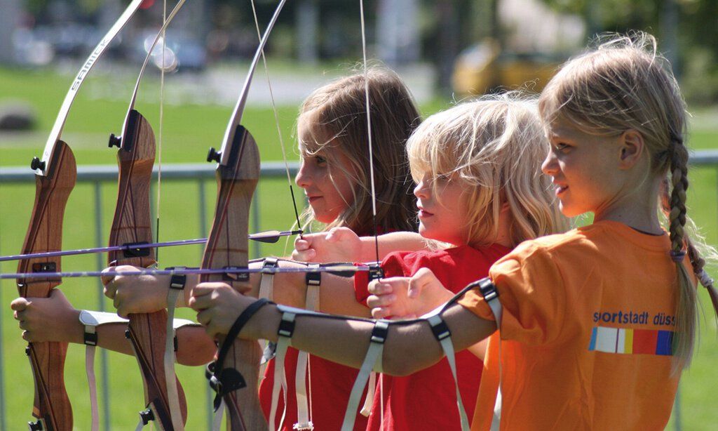 Drei Kinder beim Bogenschießen