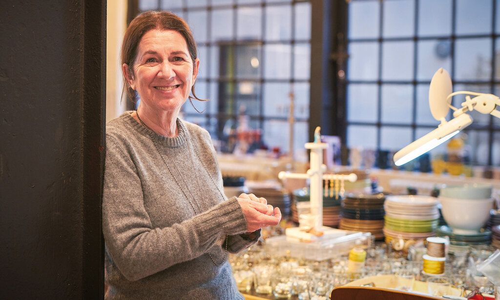 Eine Frau steht in einem Geschäft und lächelt in die Kamera