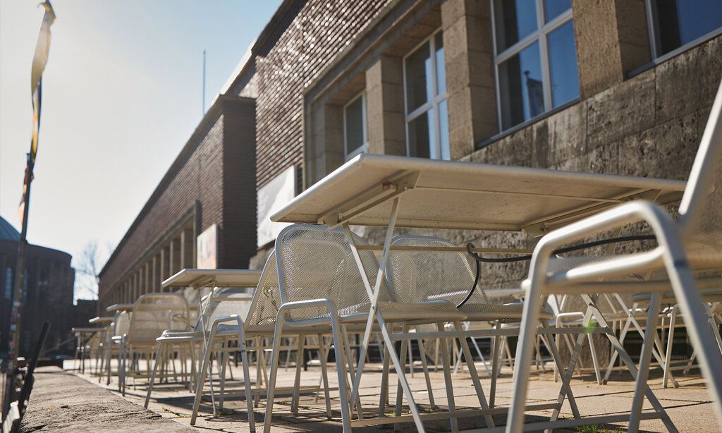 Außenansicht des NRW Forums mit Tischen und Stühlen