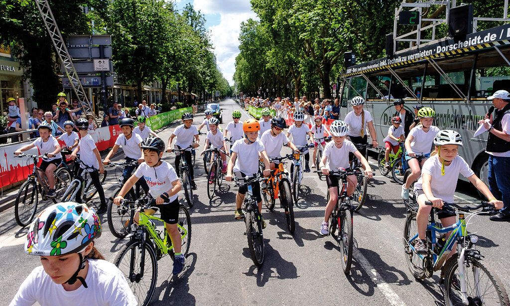 Viele Kinder mit Fahrradhelmen fahren auf der Königsallee Fahrrad, Wettbewerb