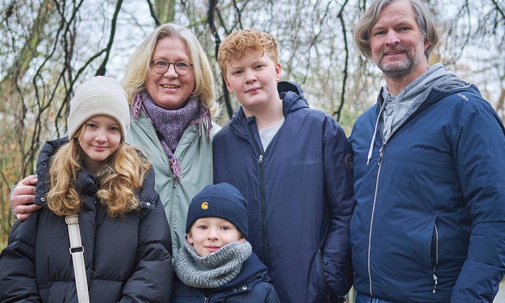 Vater, Mutter, eine Tochter, zwei Söhne vor winterlichen Bäumen