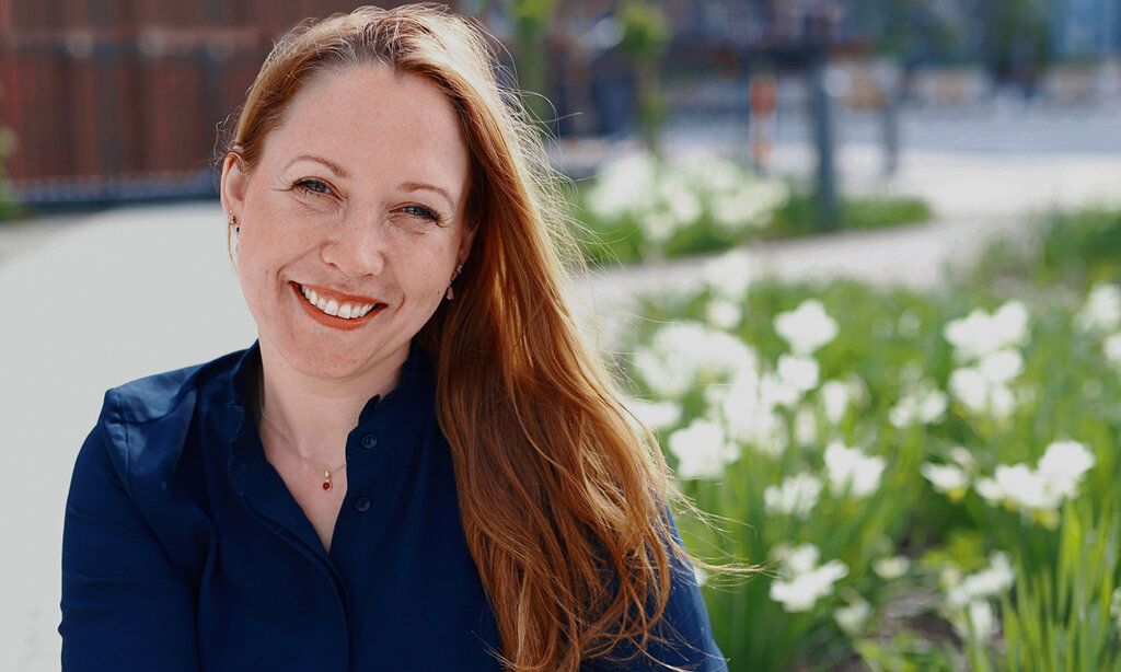 Porträt der Autorin Susanne Mierau, draußen, unscharfer Hintergrund, Platz mit Bepflanzung