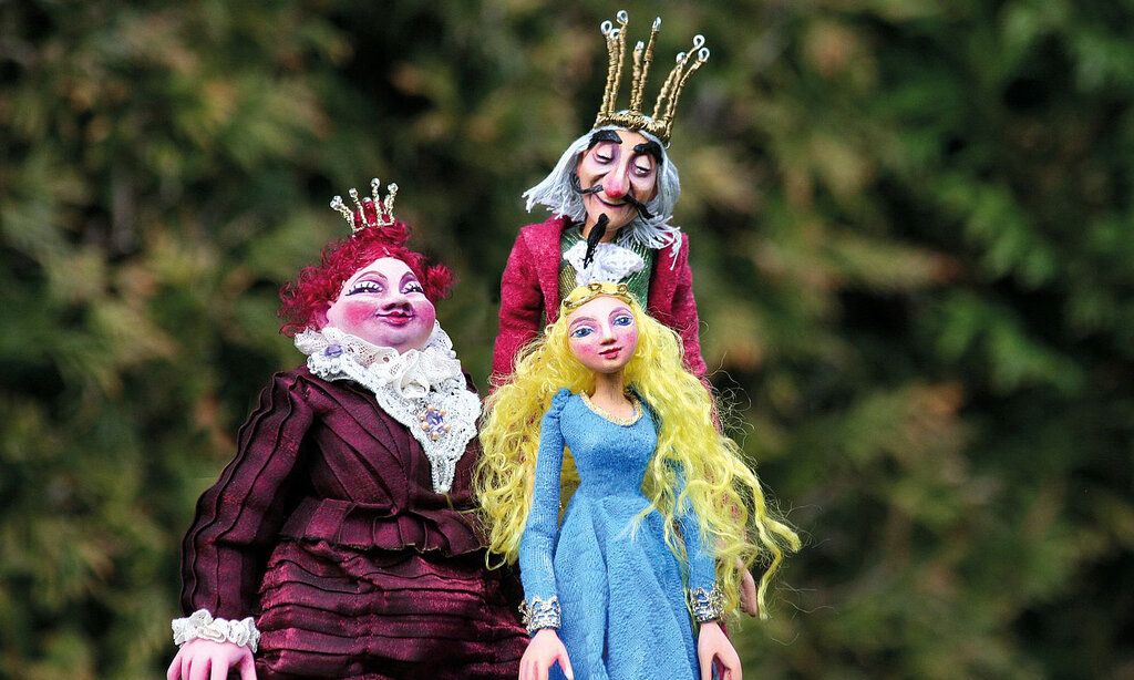 drei Handspielpuppen Königin, König, Prinzessin vor Gebüsch