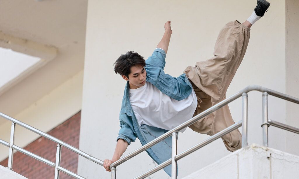 junger Mann springt an einem Geländer hoch