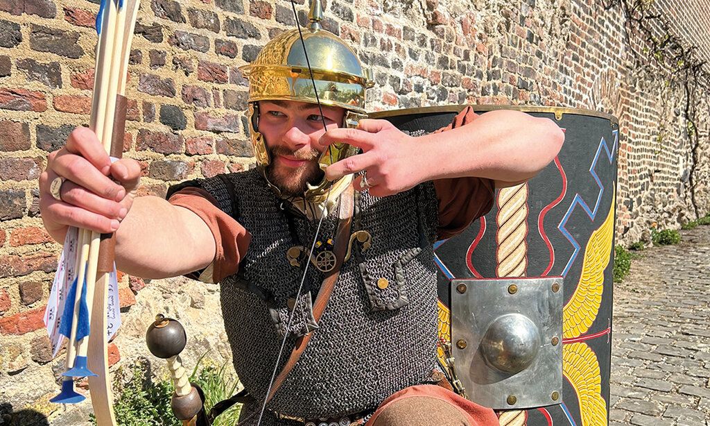 Ritter mit Pfeilund Bogen vor alter Mauer