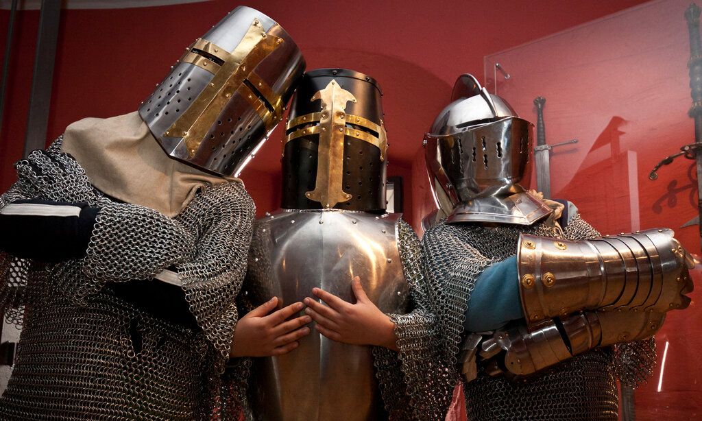drei Personen posieren in Ritterrüstungen im Kindermuseum Adlerturm