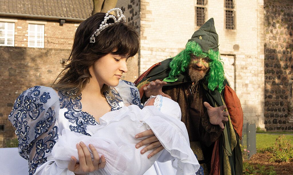 ein Schauspieler und eine Schauspielerin stellen eine Szene aus dem Märchen Rumpelstilzchen nach